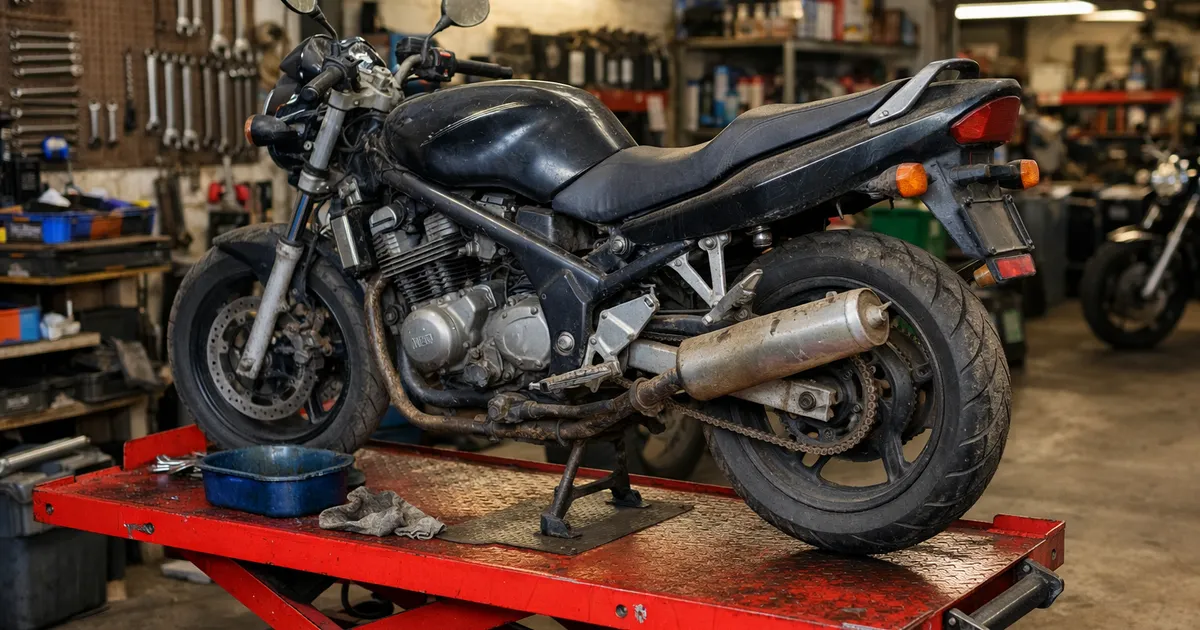 Moto de segunda mano sobre un elevador de taller con fondo limpio, lista para revisión